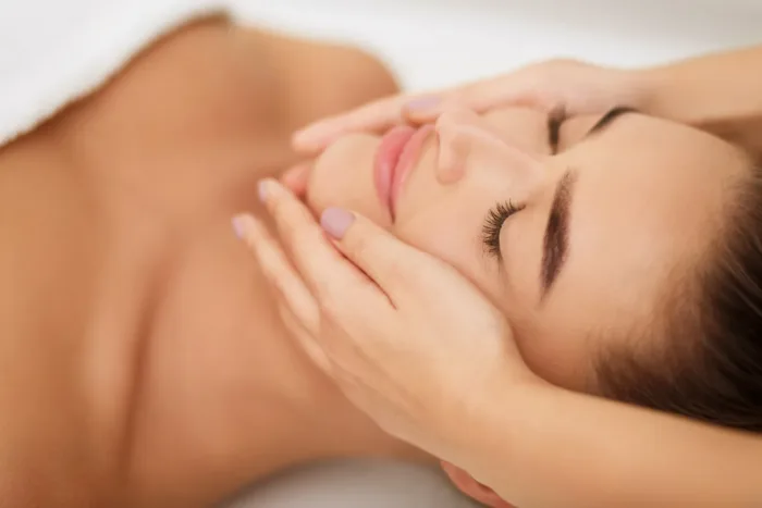 Frau genießt eine wohltuende Gesichtsmassage – geschlossene Augen, sanfte Berührung und ruhige Atmosphäre