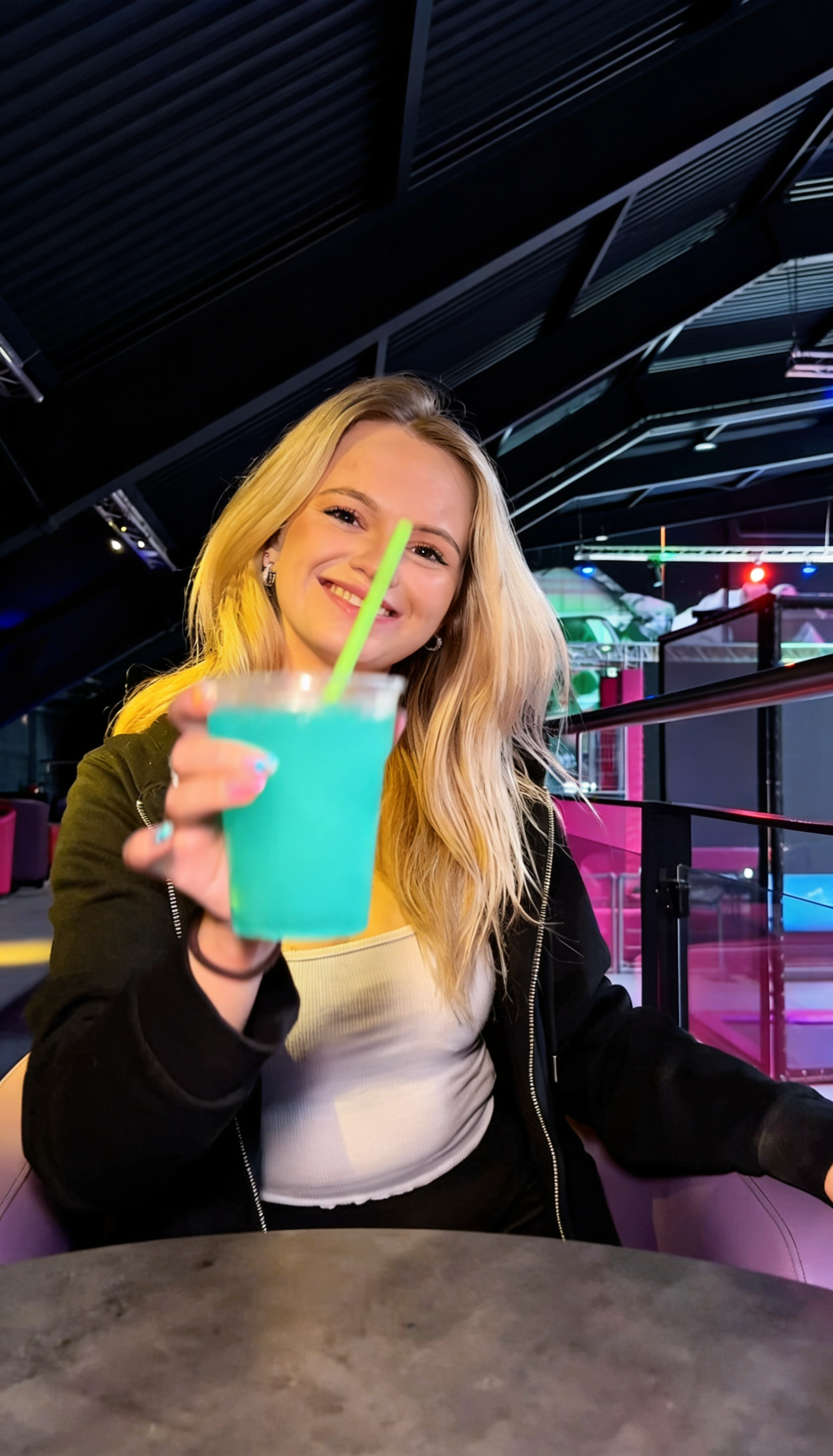 Frau hält ein blaues Slusheis im HI FLY Hilden – Erfrischung im Indoor-Freizeitpark mit Trampolin- und Actionbereich
