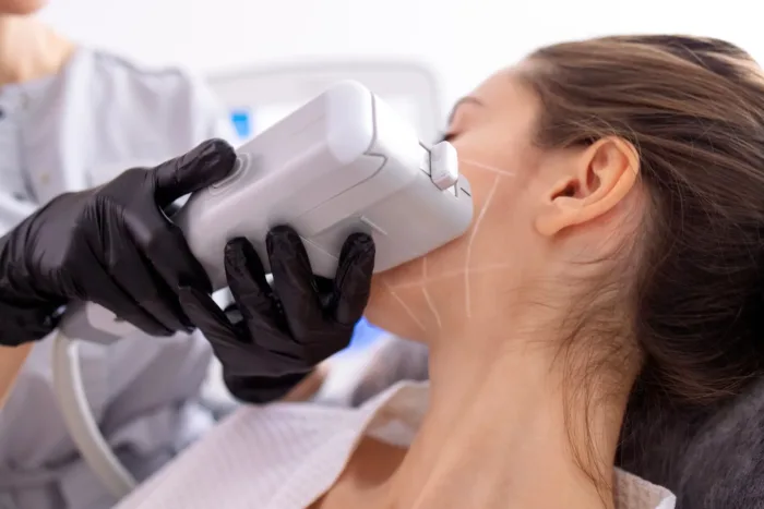 Frau bei einer HIFU-Lifting-Gesichtsbehandlung mit medizinischem Gerät