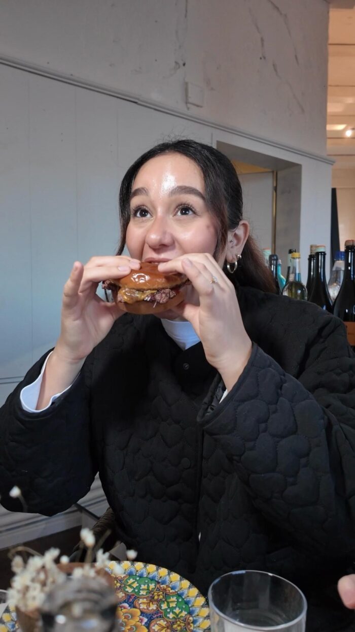 Frau beißt in einen Burger in einem modernen Restaurant