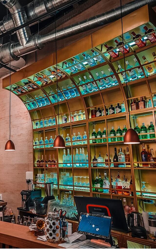 Moderne Bar mit bunt beleuchteter Decke und gut sortierten Flaschen in Wiesbaden