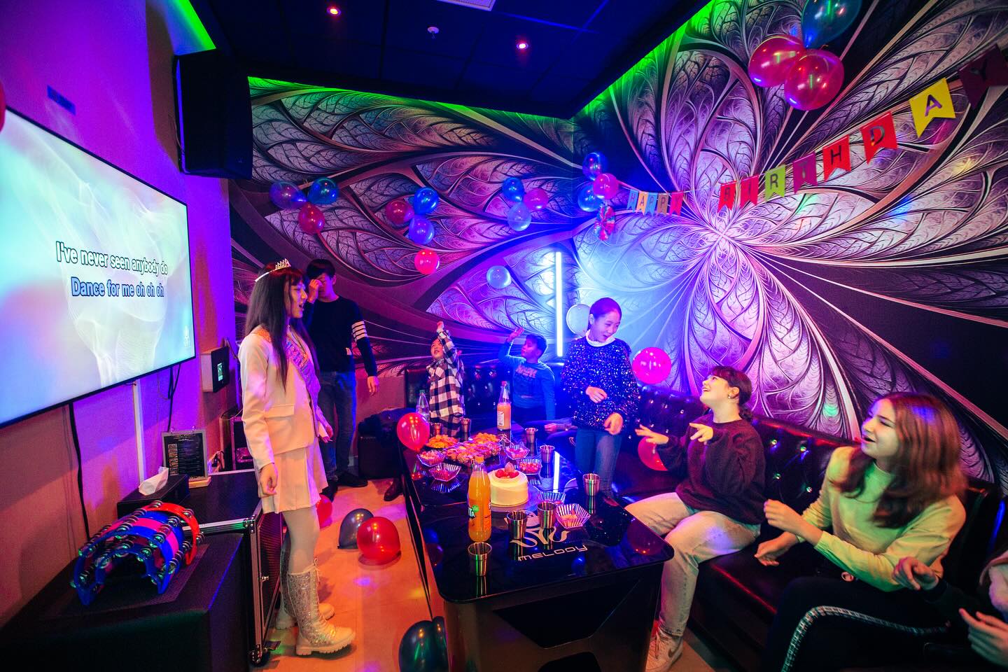 Gruppe junger Menschen feiert in bunter Lounge der Melody Party Box Wiesbaden