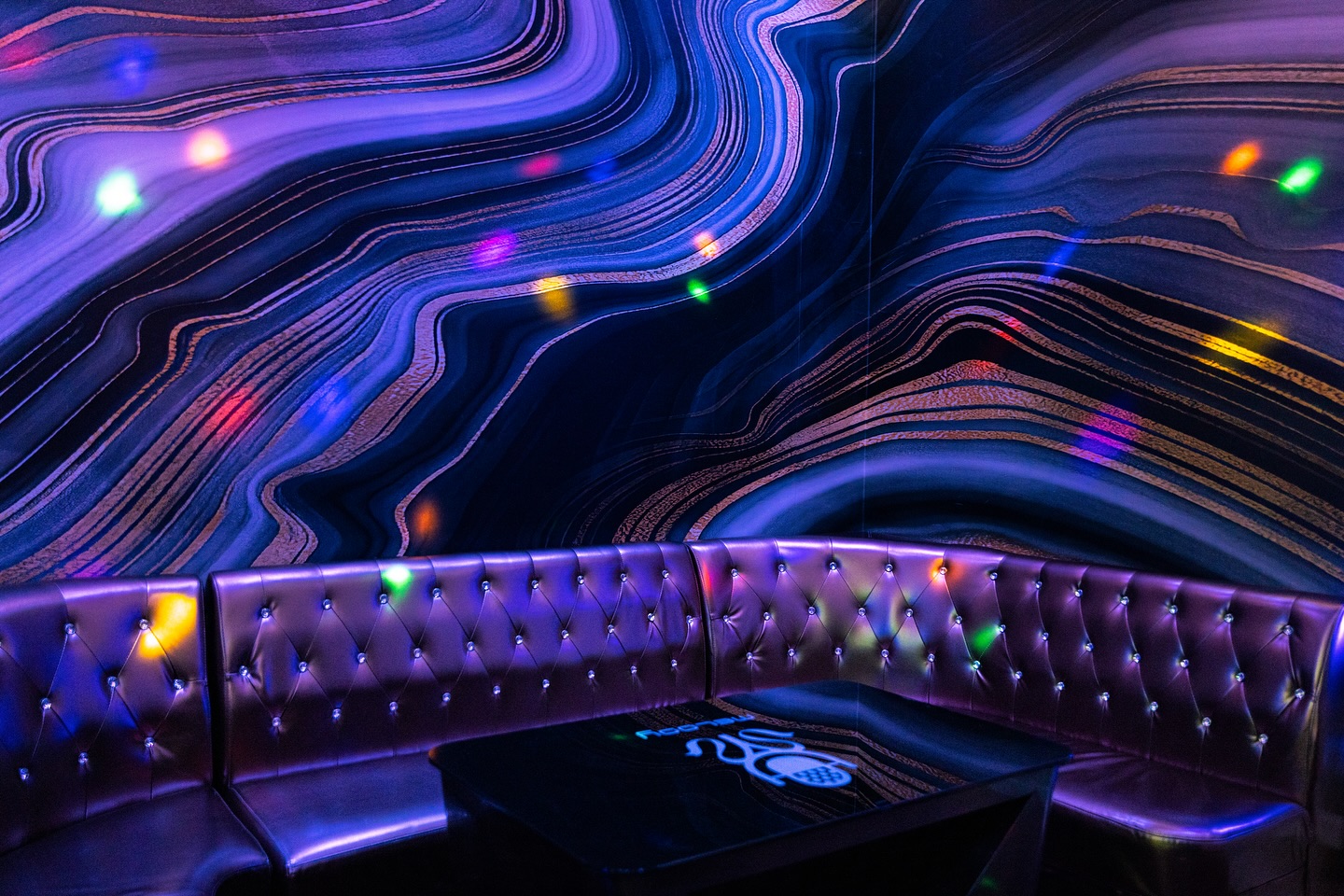 Stylische Lounge mit futuristischer Lichtwand und lila Sitzbank in Wiesbaden