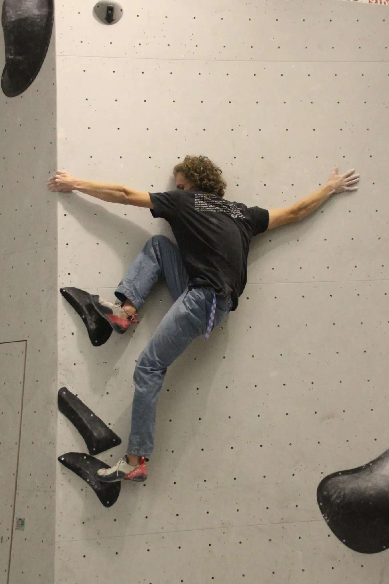 Mann beim Klettern an der Boulderwand im Sportpoint Meckenheim – konzentrierte Körperhaltung auf strukturierter Wand