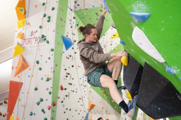 Sportler beim Bouldern an einer farbigen Kletterwand im Sportpoint Meckenheim