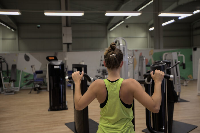Frau trainiert den Rücken an einem Fitnessgerät im Sportpoint Meckenheim