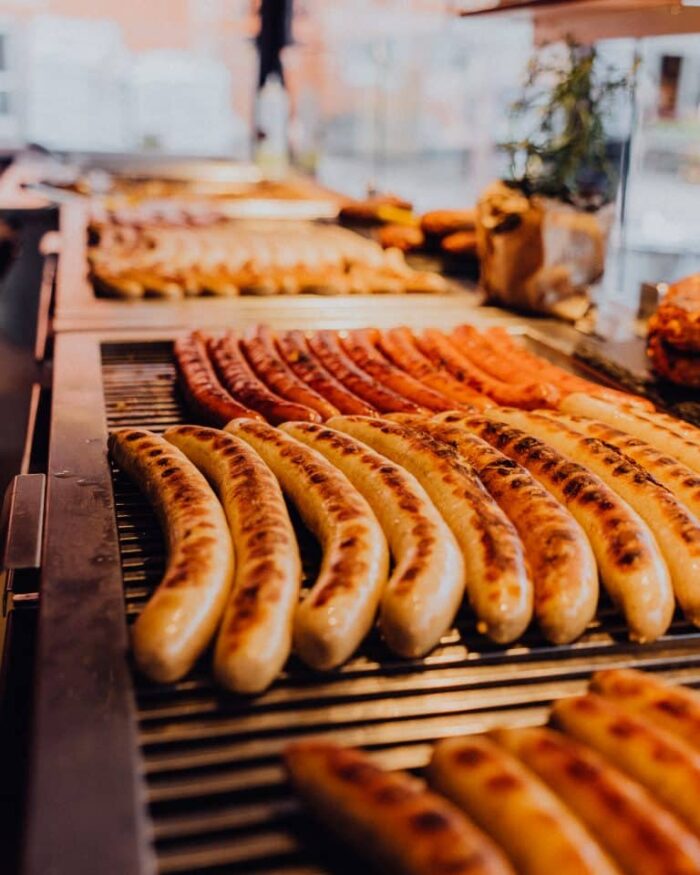 Frisch gegrillte Bratwürste auf dem Rost bei Extrawurst, goldbraun und saftig angerichtet