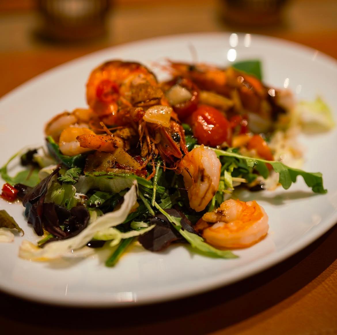 Frischer Rucolasalat mit gebratenen Garnelen, Cherrytomaten und Balsamicodressing im Ristorante La Vetra