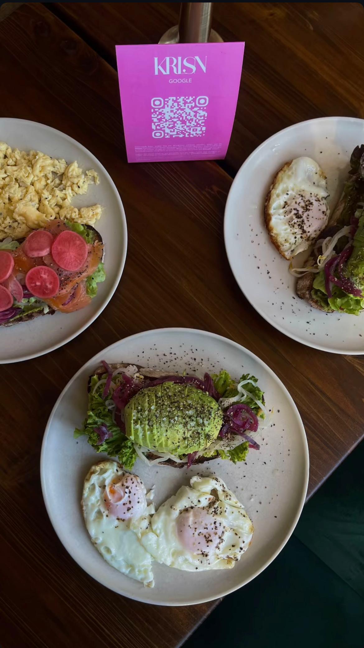 Frühstücksteller im KARLSON Darmstadt mit Avocado-Toast, Spiegelei, Rührei, Lachs und Radieschen auf Sauerteigbrot