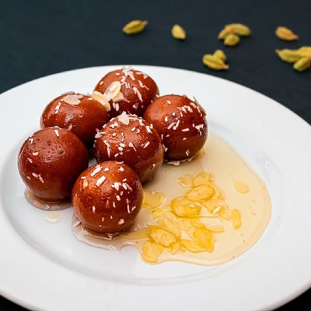 Gulab Jamun Dessert auf einem weißen Teller, serviert bei Meena Kumari in Berlin