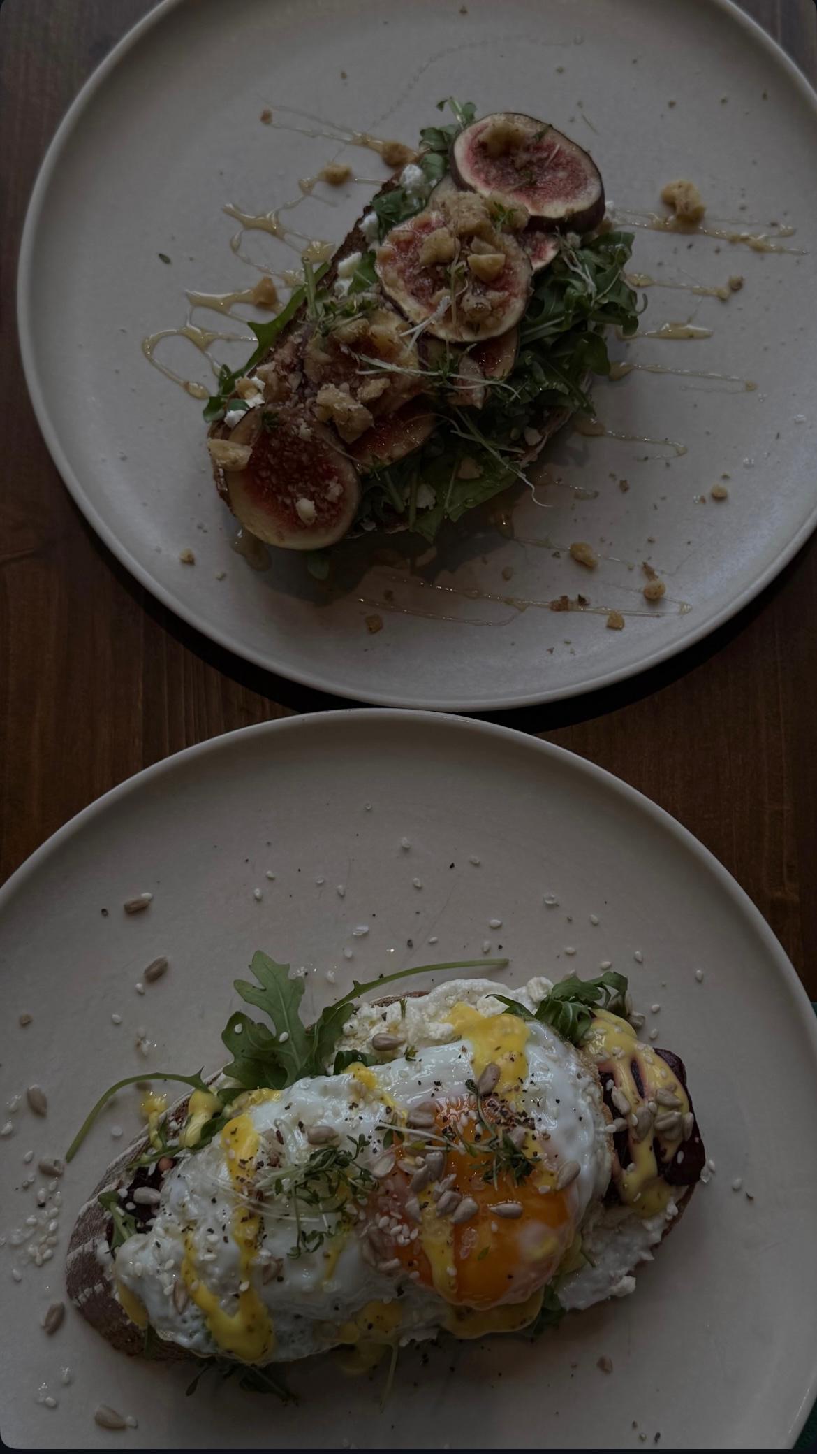 Zwei Frühstücks-Toasts im KARLSON Darmstadt, einer mit Feigen, Walnüssen und Honig, der andere mit Spiegelei, Kresse und Sauce auf Sauerteigbrot