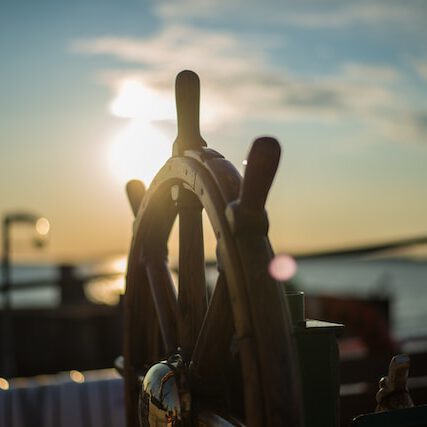 Steuerrad eines Boots im Sonnenuntergang bei der Bootsschule und Charter Berlin