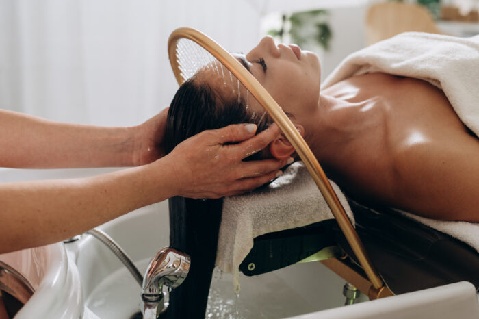 Frau bei entspannender HeadSpa-Kopfhautmassage