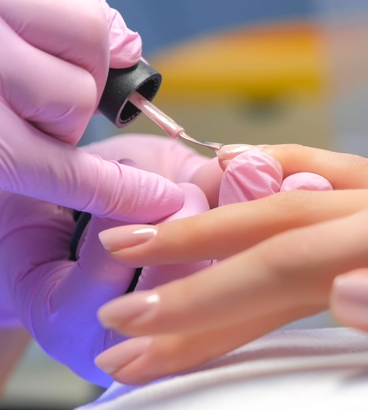 Nahaufnahme einer Maniküre mit präzisem Auftragen von Nagellack
