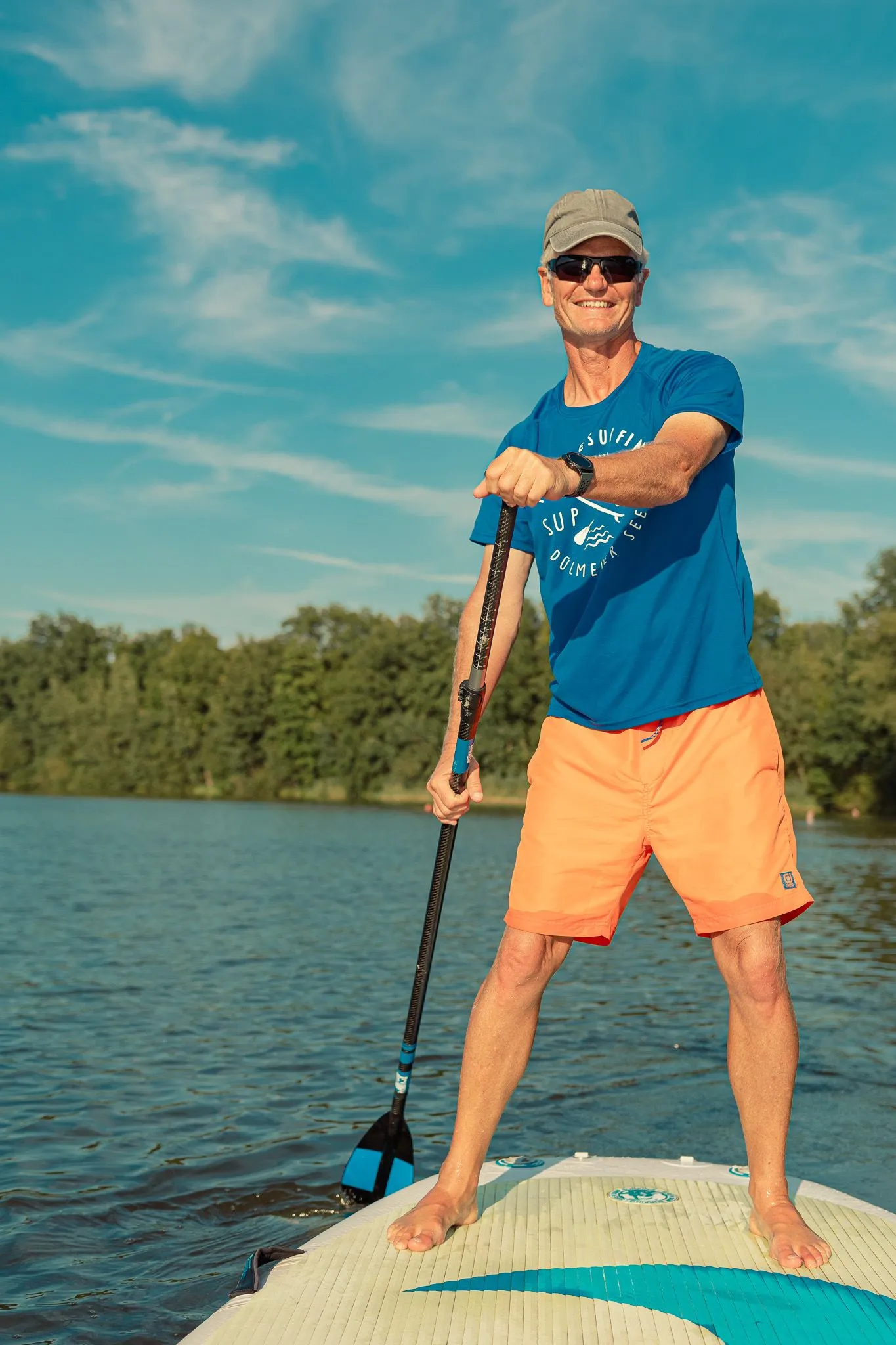 : Mann beim Stand-up-Paddling auf dem Halterner See mit Paddel und Sonnenbrille