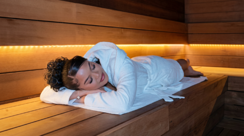 Private Wellness Oase bei Shangrilla Schwelm – Gast entspannt im Bademantel auf einer Saunabank und genießt eine ruhige Wellnessauszeit