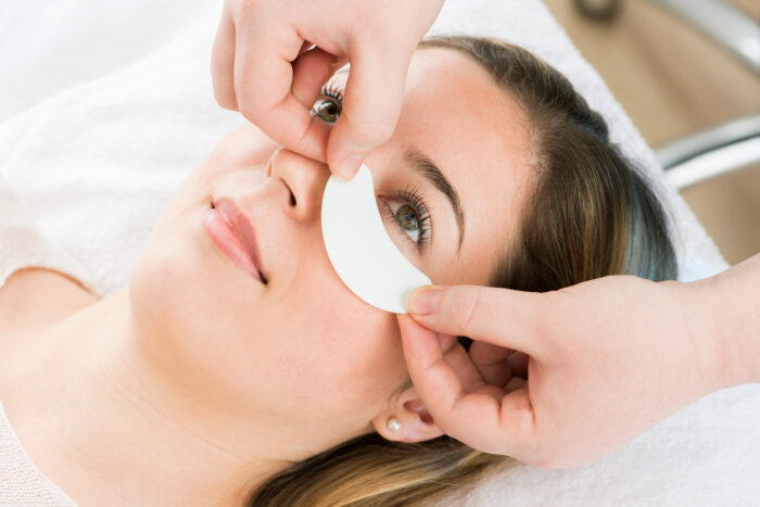 Vorbereitung auf eine Wimpernverlängerung mit Augenpad unter dem Auge