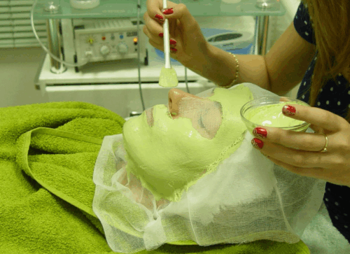 Frau bei Gesichtsbehandlung mit grüner Pflegemaske im Beauty Center Berlin