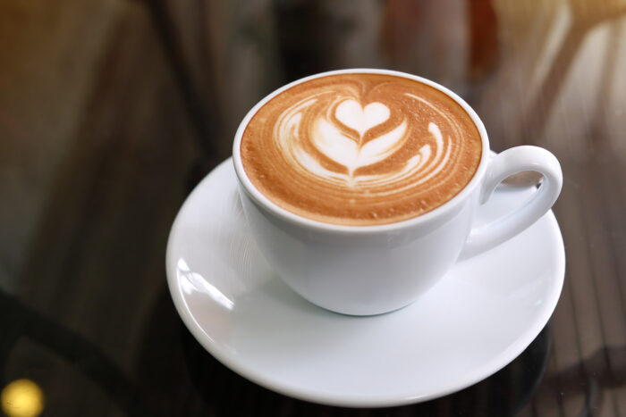 Cappuccino mit Latte Art Herz auf weißer Untertasse