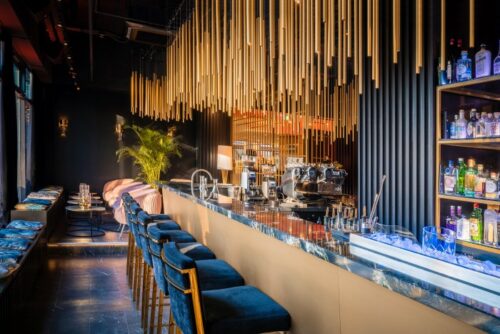 Stylischer Barbereich mit goldenen Designelementen in der House of Gin Bar im Hotel Palace Berlin