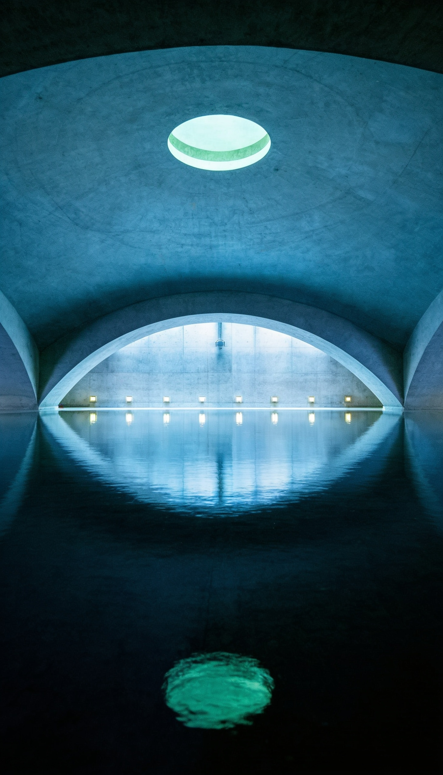 Spiegelndes Wasserbecken im Liquidrom Berlin – ruhiges Thermalbecken unter markanter Kuppelarchitektur für Floating, Entspannung und Wellness
