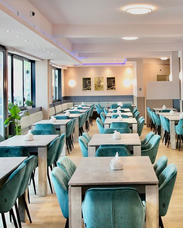 Helles und stilvolles Ambiente mit türkisfarbenen Stühlen im Restaurant Mama’s Küche in Essen