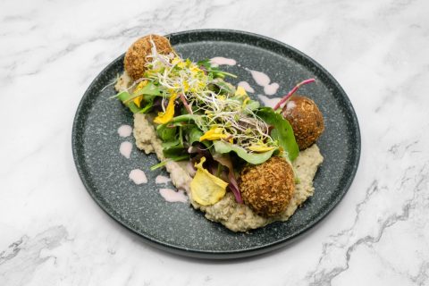 Falafelbällchen mit Avocado, Salat und cremiger Sauce kunstvoll angerichtet bei Mkhunaa Berlin