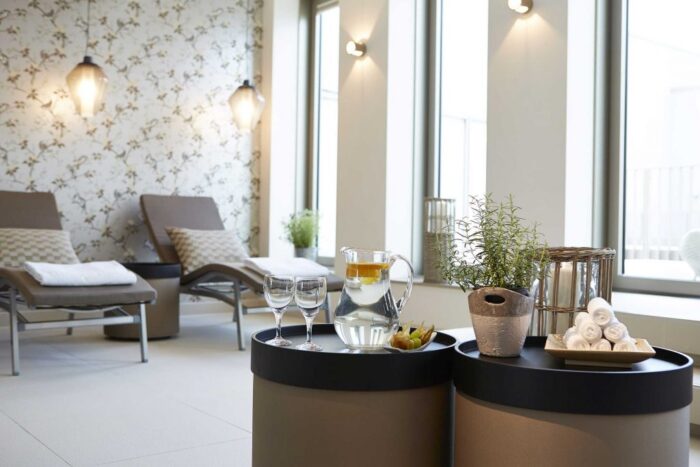 Heller Spa-Ruheraum mit Liegen, Getränken und stilvollem Ambiente in der Sky Spa & Fitnesslounge Berlin