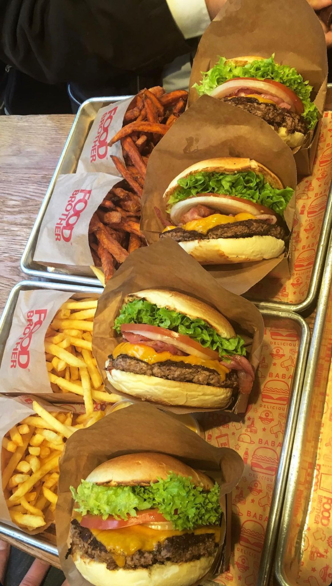 Mehrere Burger Menüs mit saftigen Burgern und knusprigen Pommes angerichtet als Streetfood Auswahl bei Food Brother in Dortmund.
