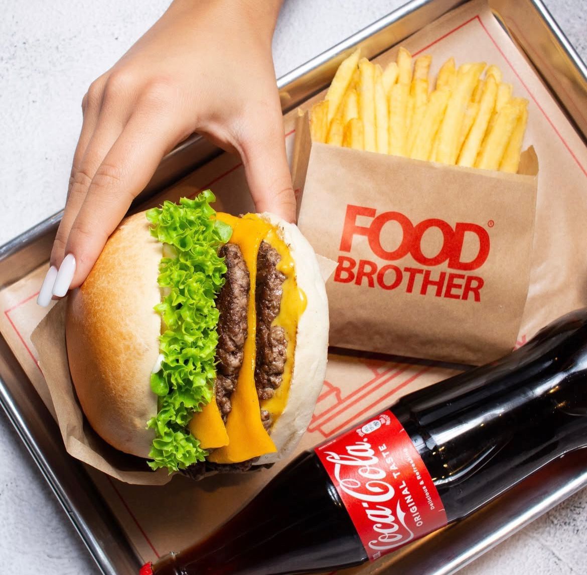 Burger Menü mit saftigem Burger, knusprigen Pommes und Cola serviert bei Food Brother in Dortmund.