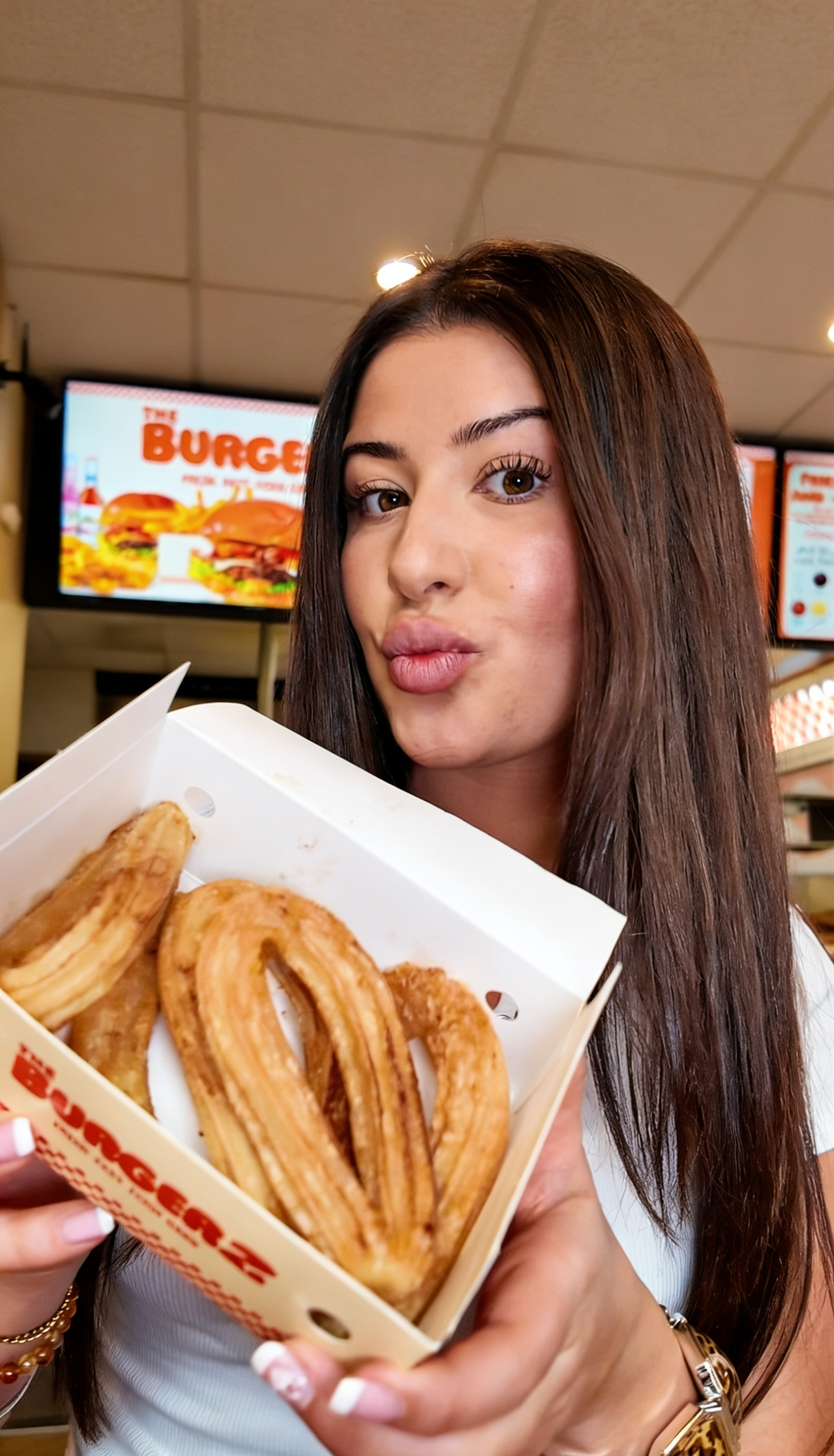 Churros bei TheBurgerz Oberhausen – goldbraun gebackene Churros mit Zucker und Zimt, präsentiert von einer Kundin im Restaurant
