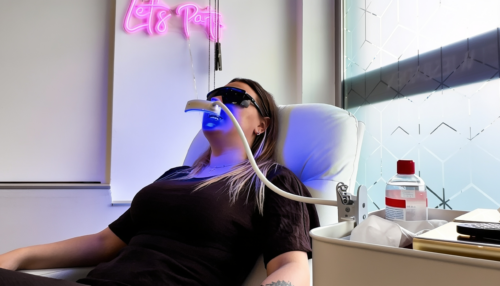 Zahnbleaching bei Piercing Clicker Wiesbaden, bei dem eine Kundin entspannt auf einer Behandlungsliege liegt und die Zähne mit LED Licht aufgehellt werden