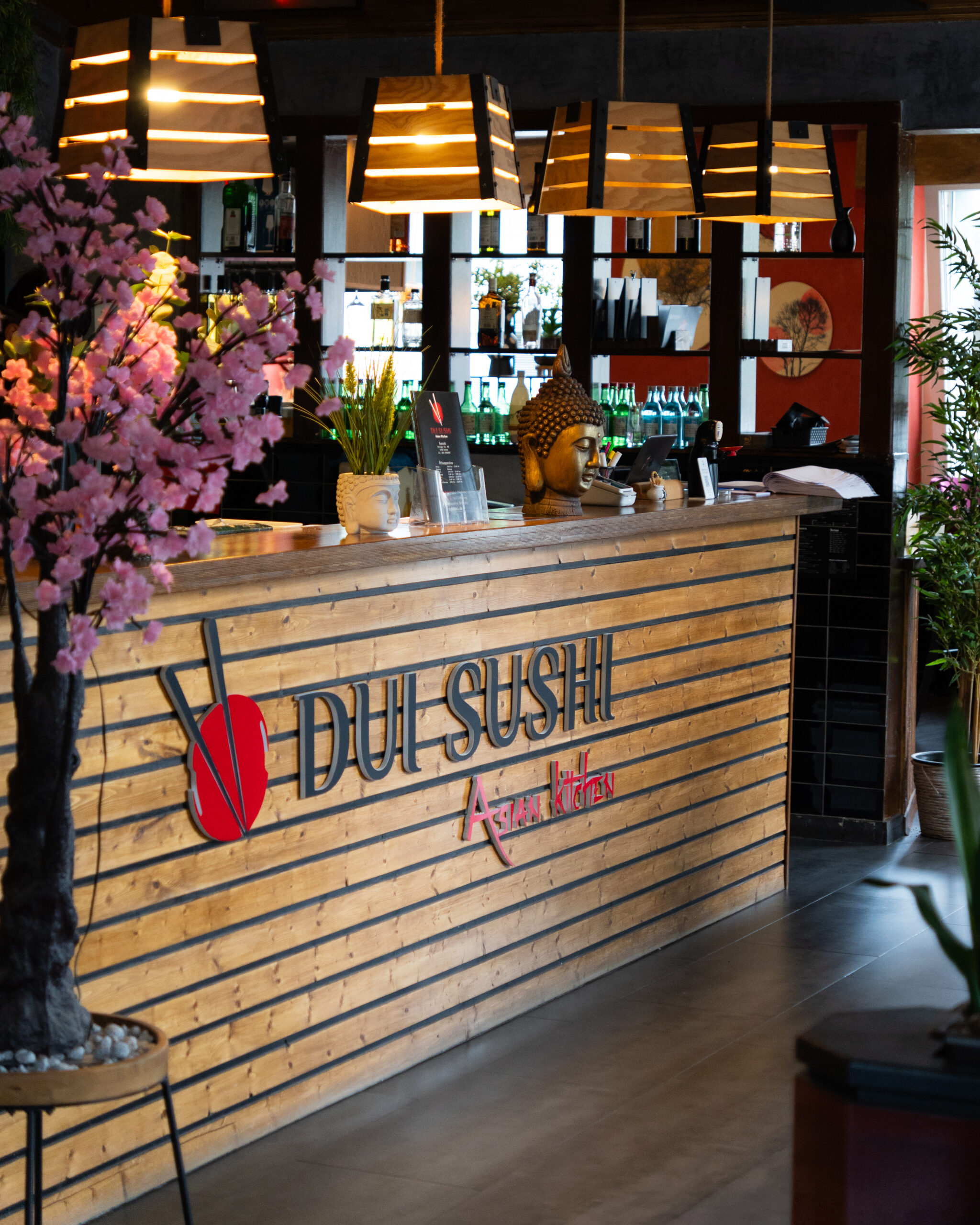 Modernes Restaurantambiente bei DUI Sushi Bochum – stilvoller Empfangsbereich mit Theke, Beleuchtung und asiatischem Flair