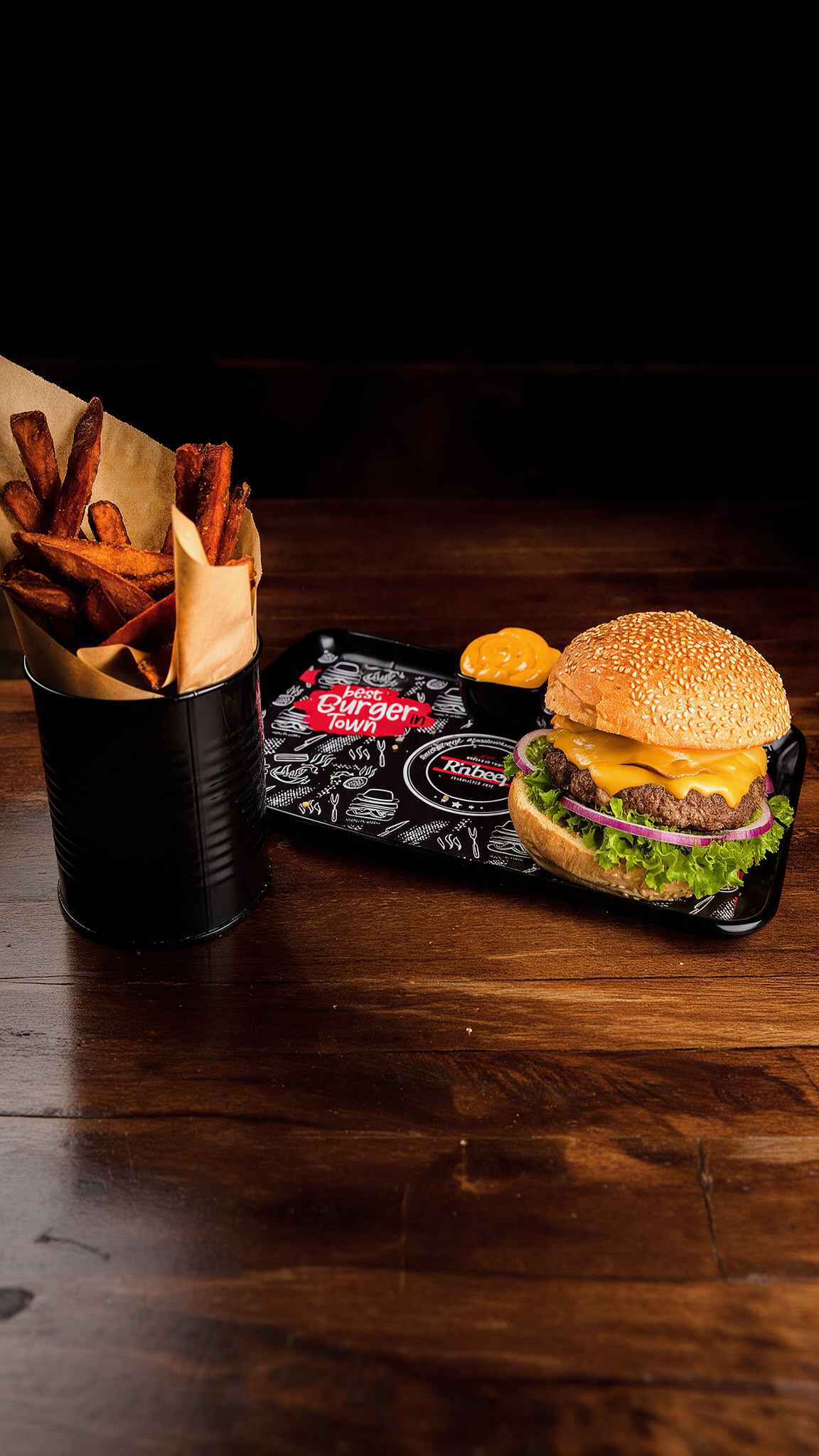 Burgermenü bei RnBeef in Duisburg mit frisch serviertem Burger, Pommes und Dip auf einem dunklen Holztisch