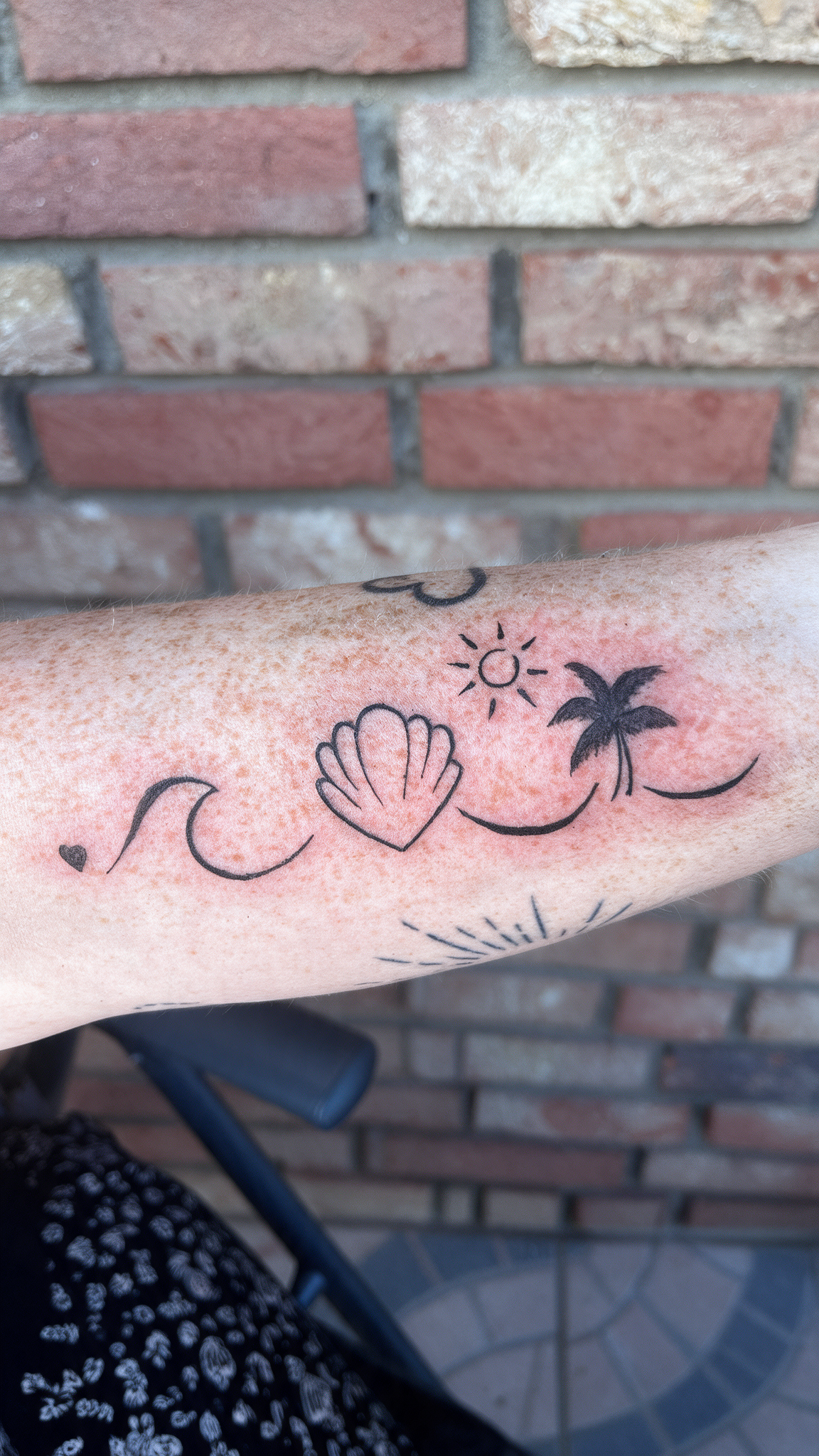 Fine Line Tattoo bei Eljo Aesthetics in Unna mit Muschel, Sonne, Welle und kleinen Sternmotiven als dezentes Beispielmotiv am Arm