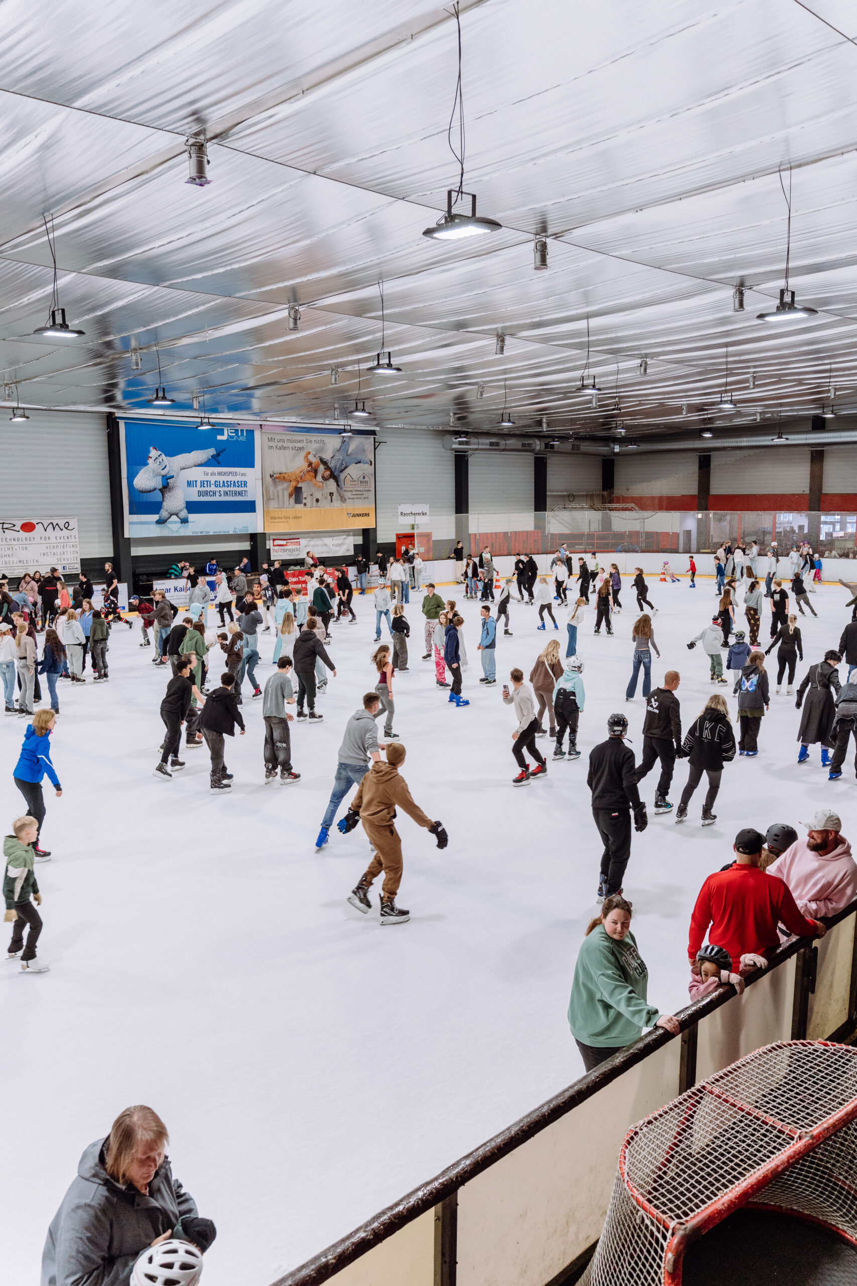 Große Eisfläche in der Eissporthalle Troisdorf mit vielen Besuchern beim Eislaufen als wetterunabhängiges Freizeiterlebnis für Familien und Freunde