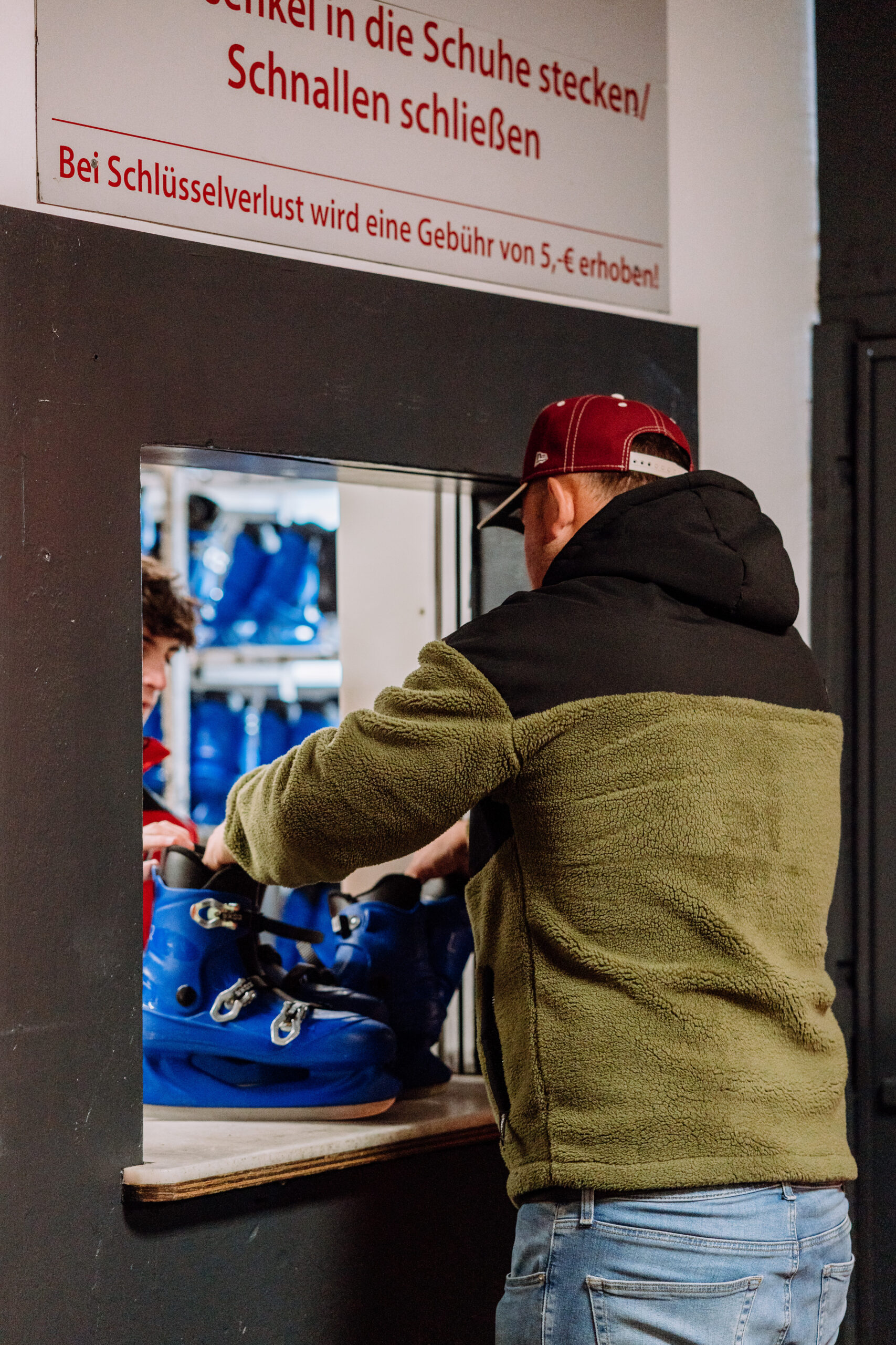 Besucher am Schlittschuhverleih der Eissporthalle Troisdorf beim Ausleihen von Schlittschuhen für das Eislaufen auf der Eisfläche