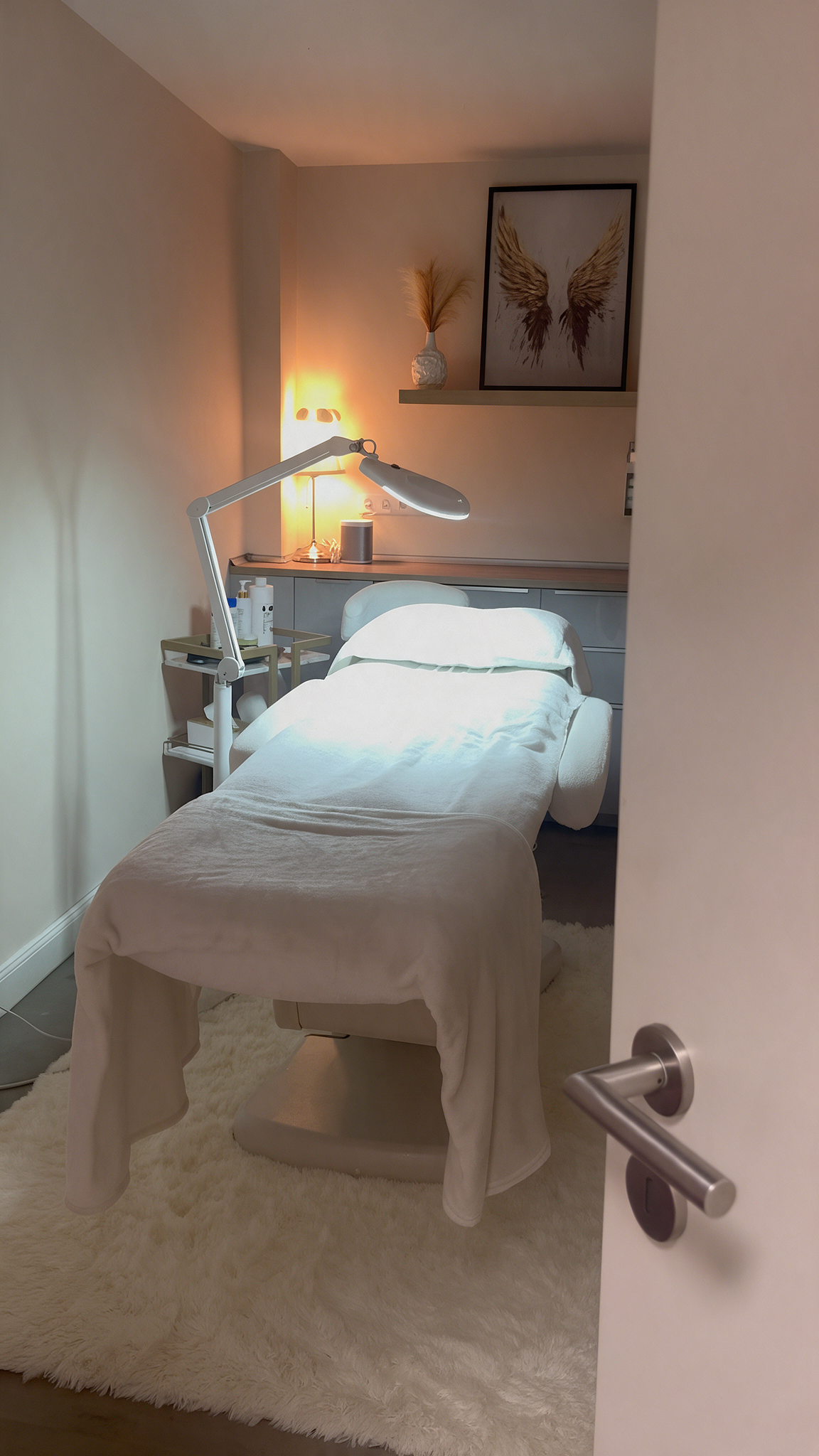 Behandlungsraum bei Luxbeauty Hair in Düsseldorf mit vorbereiteter Behandlungsliege, warmer Beleuchtung und ruhiger Atmosphäre für Beauty Anwendungen