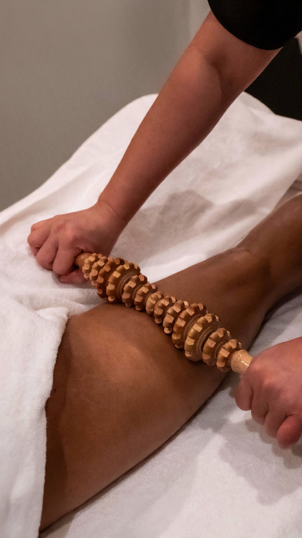 Maderomassage bei Madero & Cupping Essen mit speziell geformter Holzrolle zur intensiven Massage und Bearbeitung der Oberschenkel