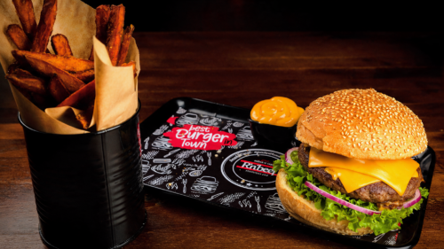 Burgermenü bei RnBeef in Duisburg mit frisch serviertem Burger, Pommes und Dip auf einem dunklen Holztisch