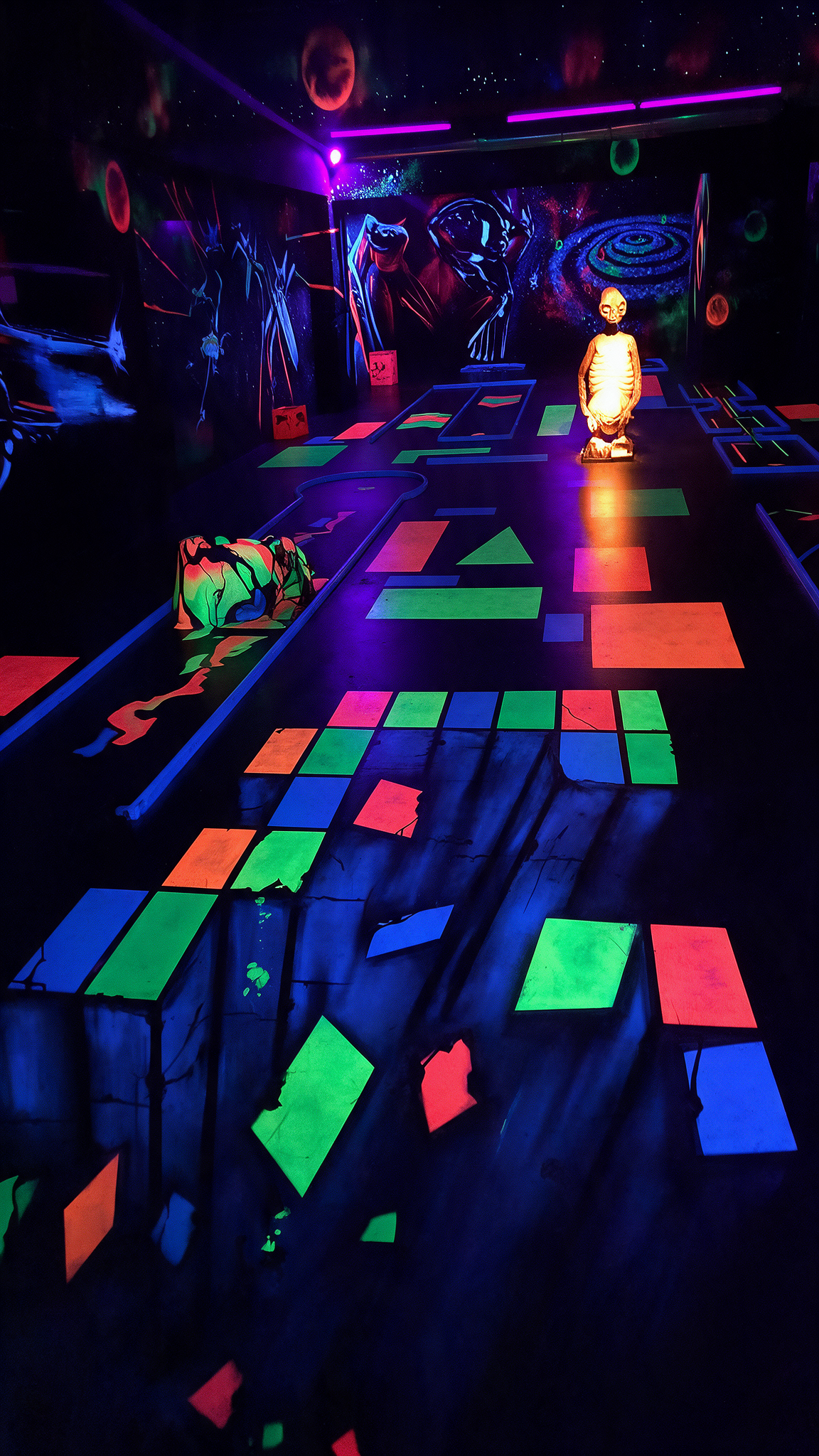 Bunte 3D Schwarzlicht Minigolfbahn bei Golf’n’Glow in Hagen mit leuchtenden Neonfeldern und fluoreszierenden Hindernissen.