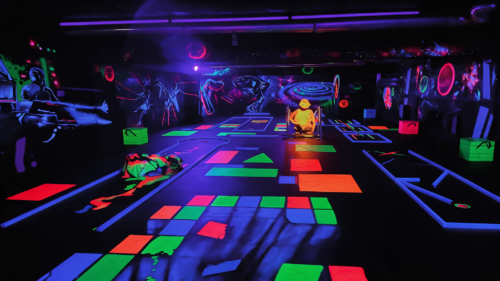 3D Schwarzlicht Minigolf bei Golf'n'Glow Hagen mit leuchtenden Minigolfbahnen, bunten Neonfarben und fantasievollen Wandmotiven in einer abgedunkelten Indoor Anlage