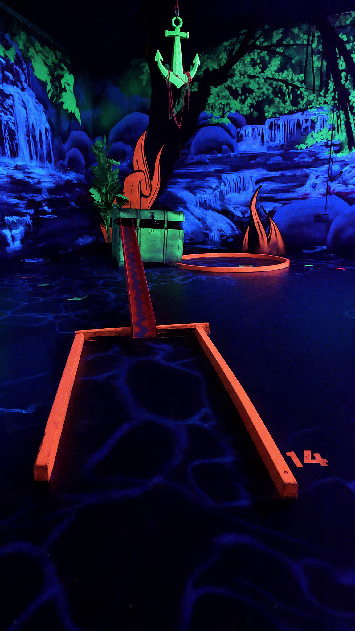 Bunte 3D Schwarzlicht Minigolfbahn bei Golf’n’Glow in Hagen mit leuchtenden Neonfeldern und fluoreszierenden Hindernissen.